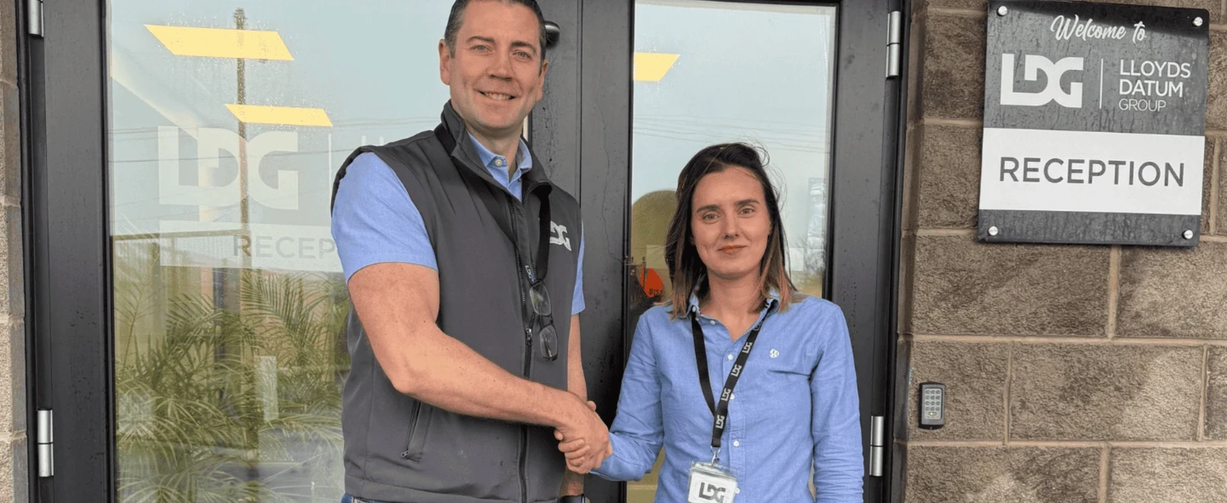 Miriam Temino and Mark Hodgen shaking hands outside of LDG Office
